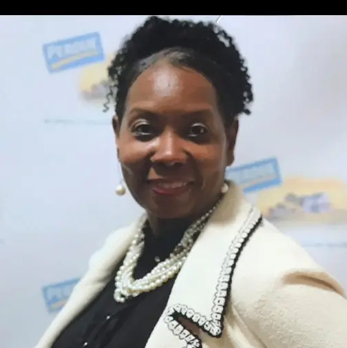 Confident woman smiling warmly in professional attire.