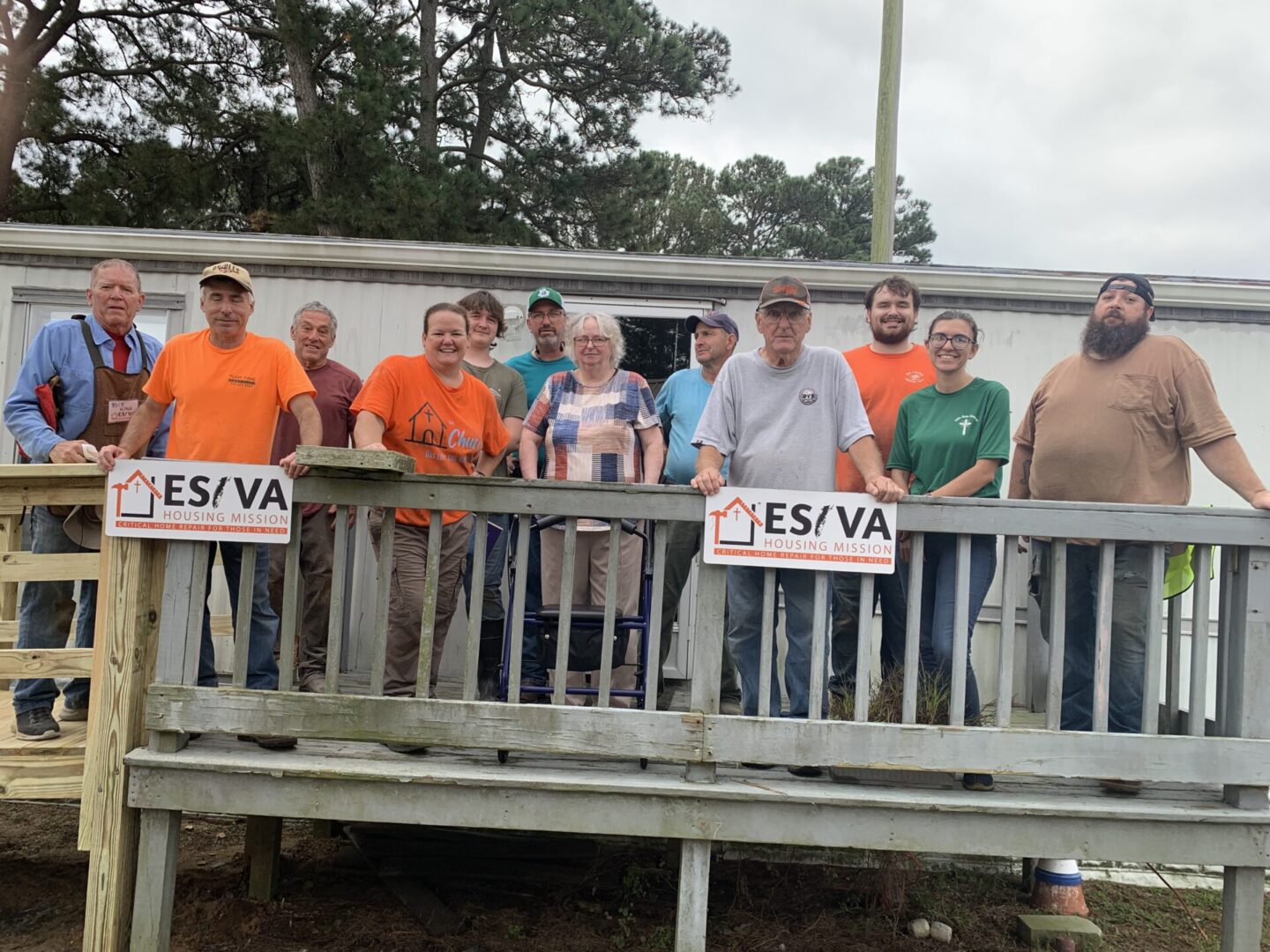 A group of men standing on a wooden deck holding 'YES/VA' signs.