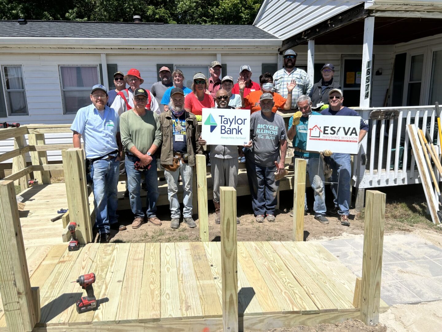 Group of people posing at a construction site with signs for Taylor Farms and ESA.