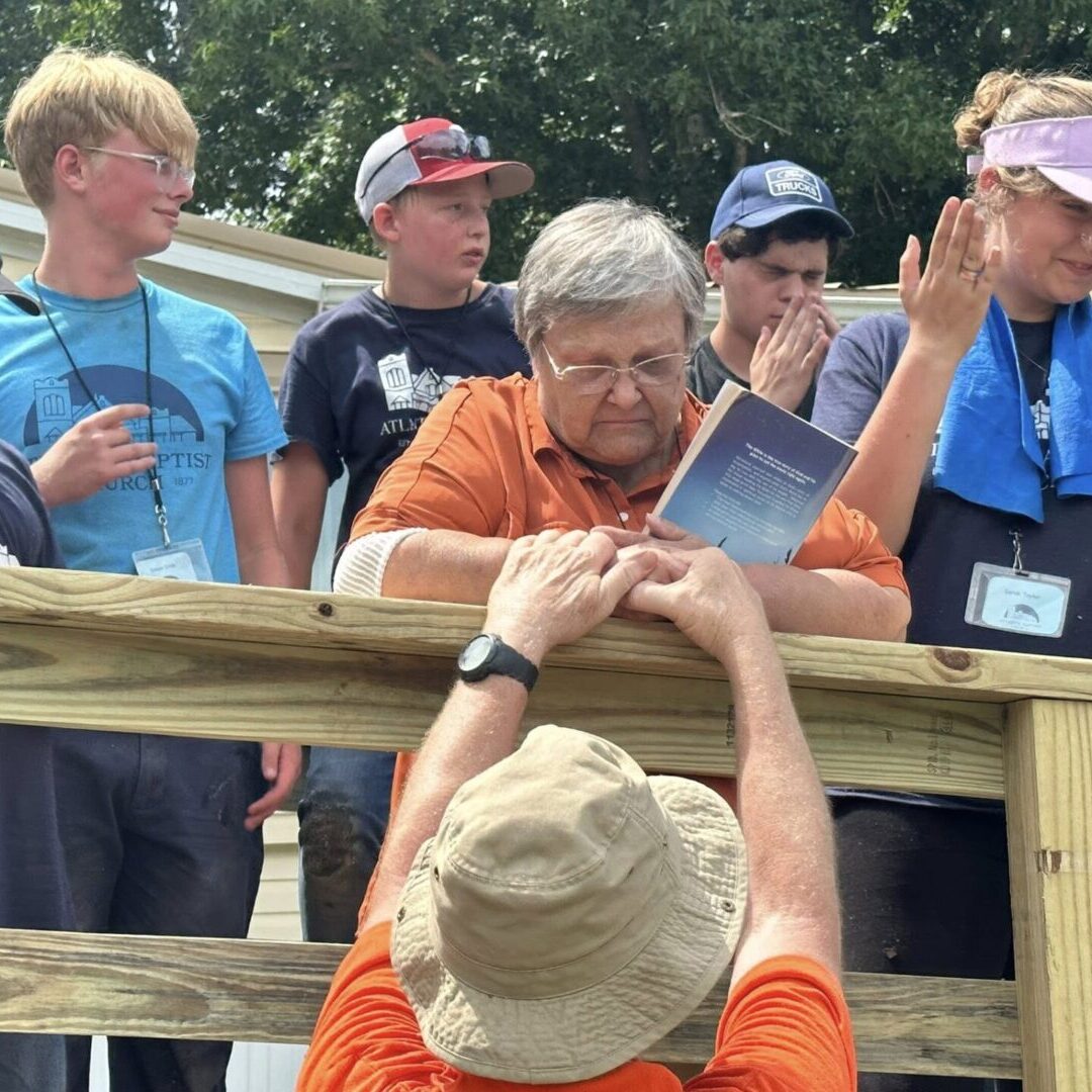 A group of people gathered outdoors, engaging in conversation and sharing a moment.